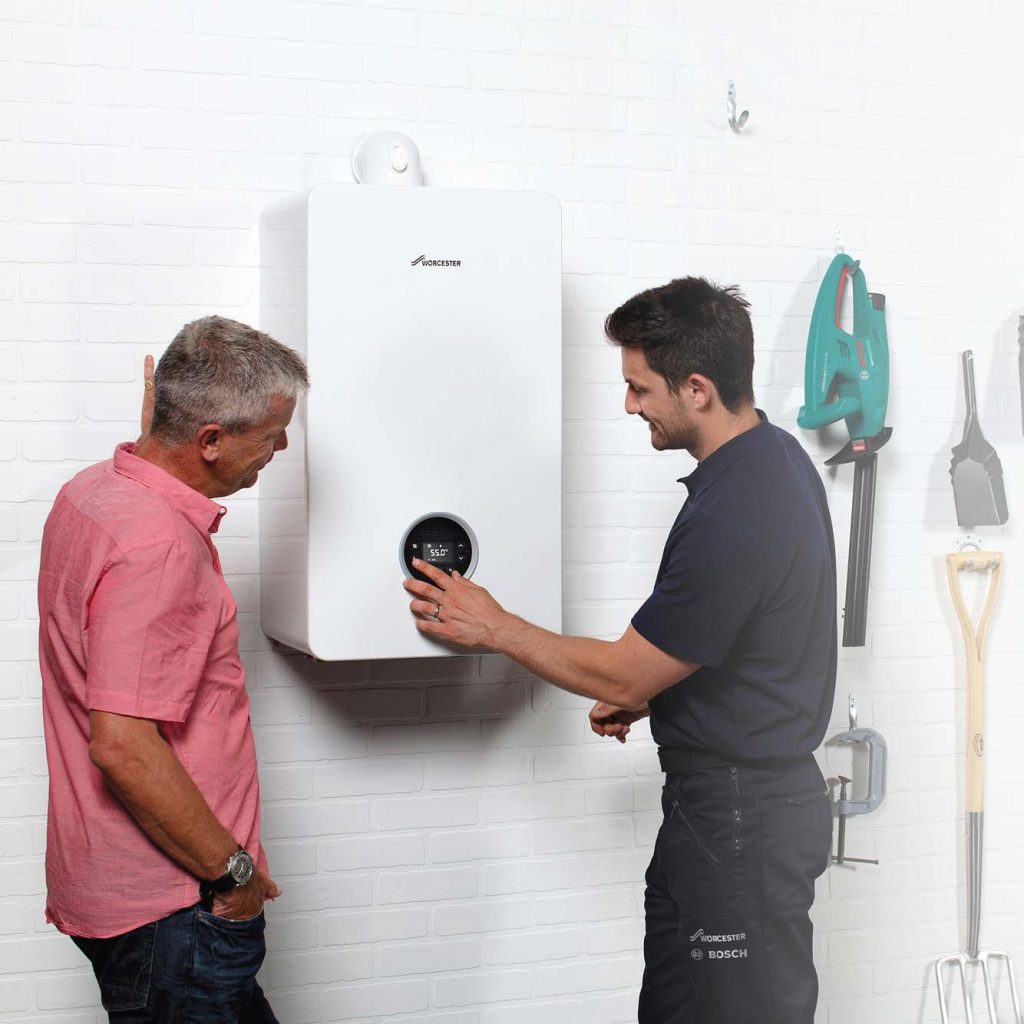 Boiler engineer showing customer new boiler